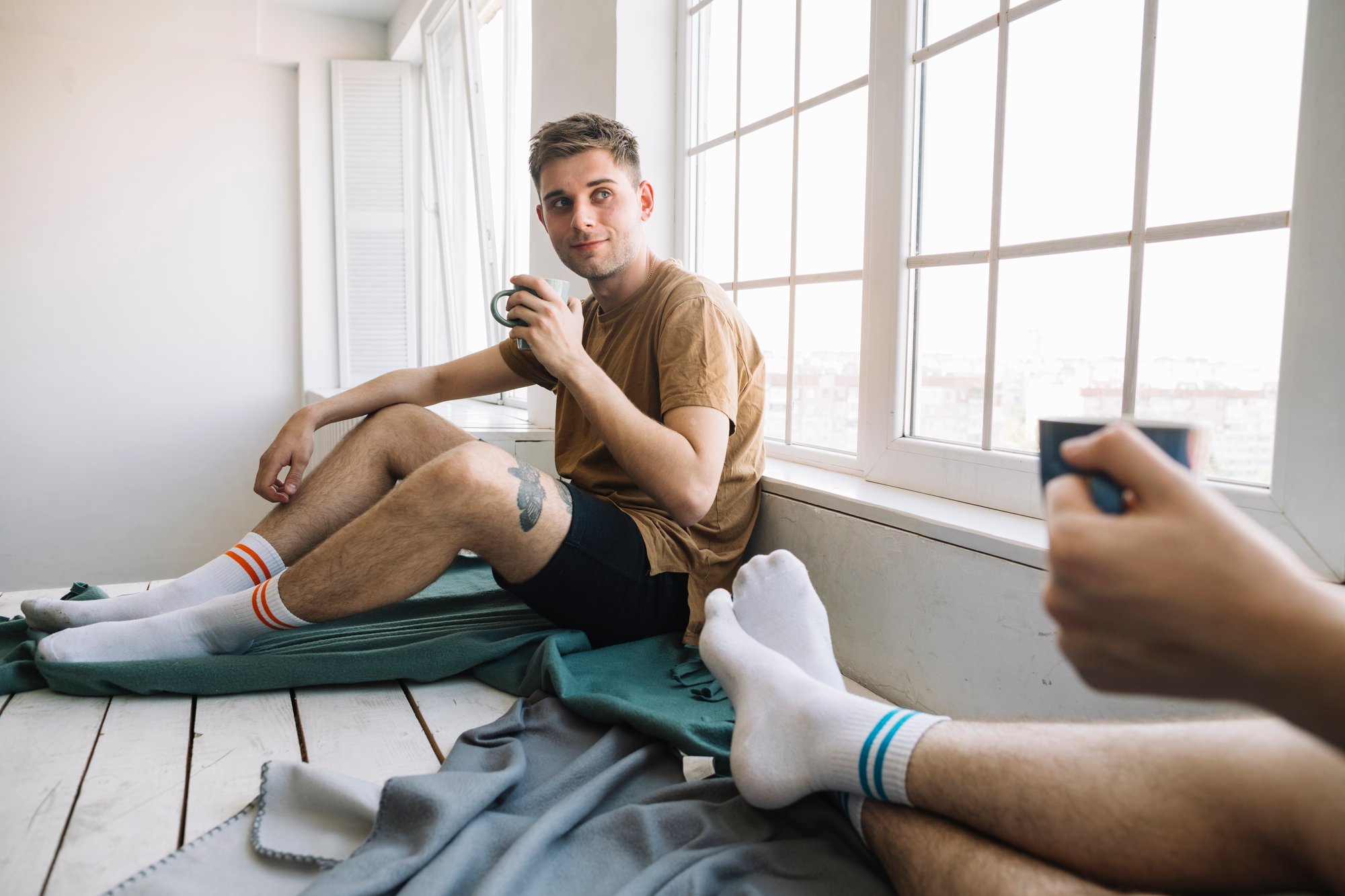 young-man-looking-his-friend-while-holding-coffee-cup
